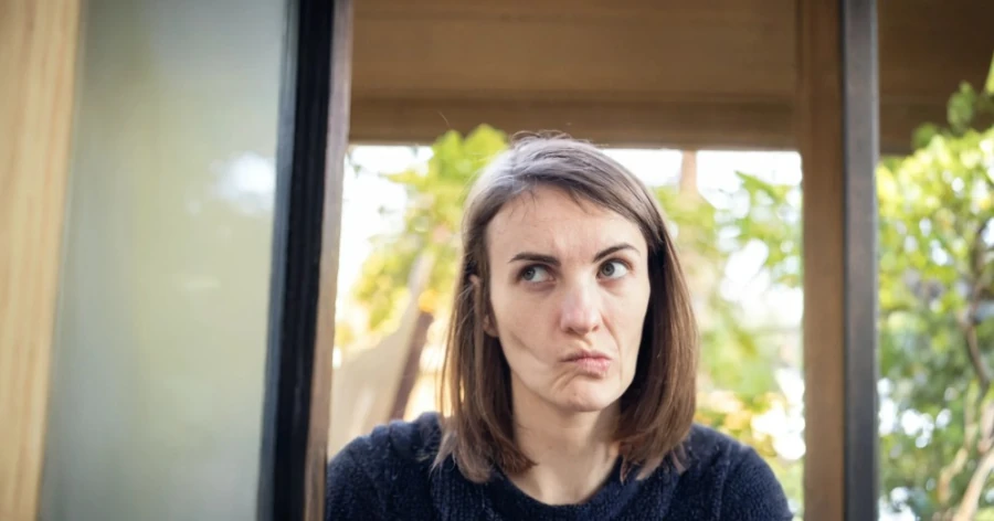 Femme qui semble dégoutée par quelque chose, un peu méprisante