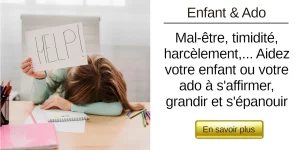 Une petite fille la tête couchée sur son bras sur un bureau qui tient un panneau Help dans la main